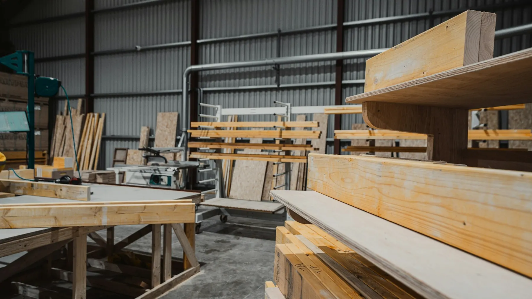 Timber beams and sheet materials stacked in a timber shed