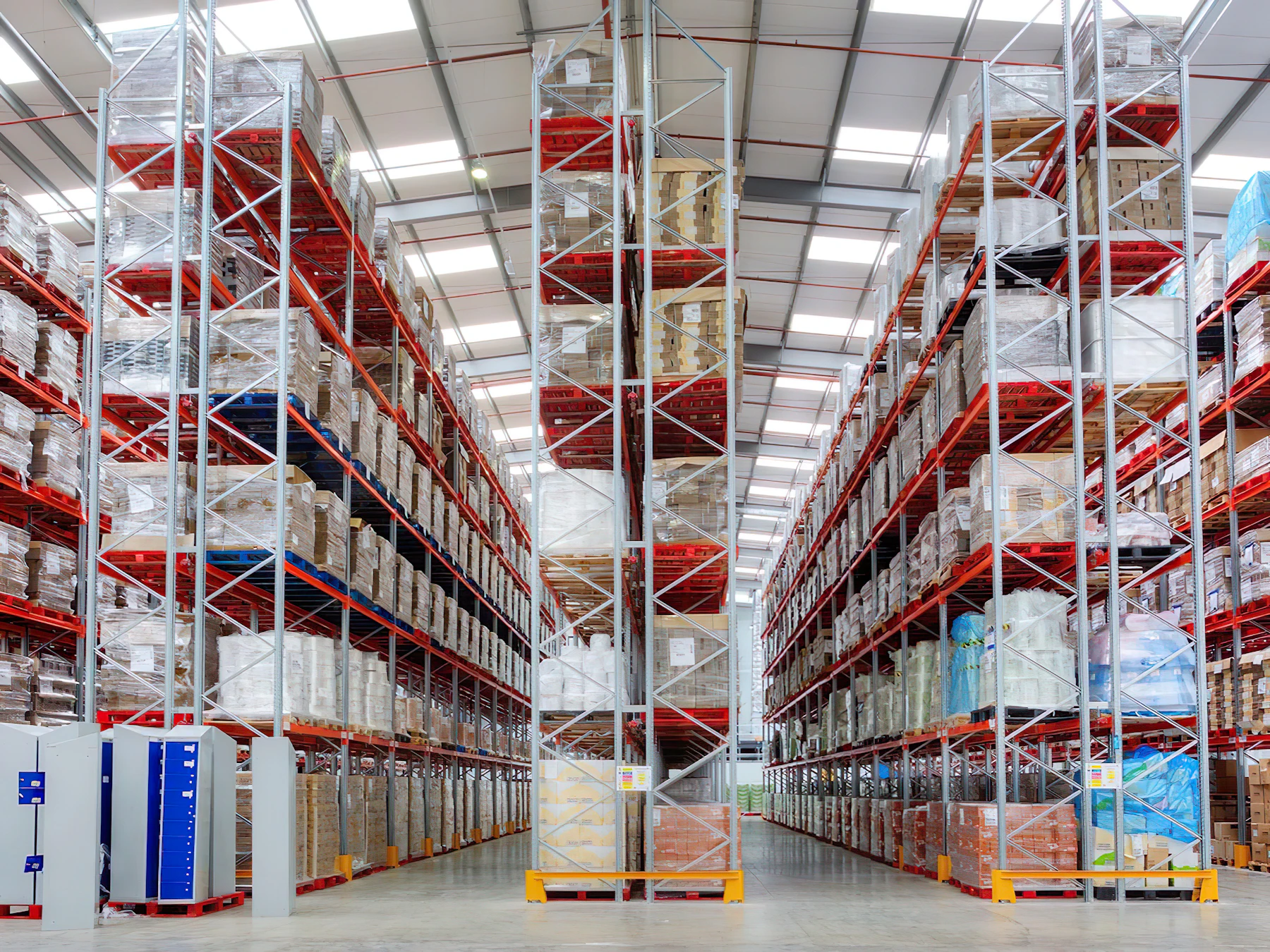 Tall pallet racking filled with wrapped goods in a large warehouse